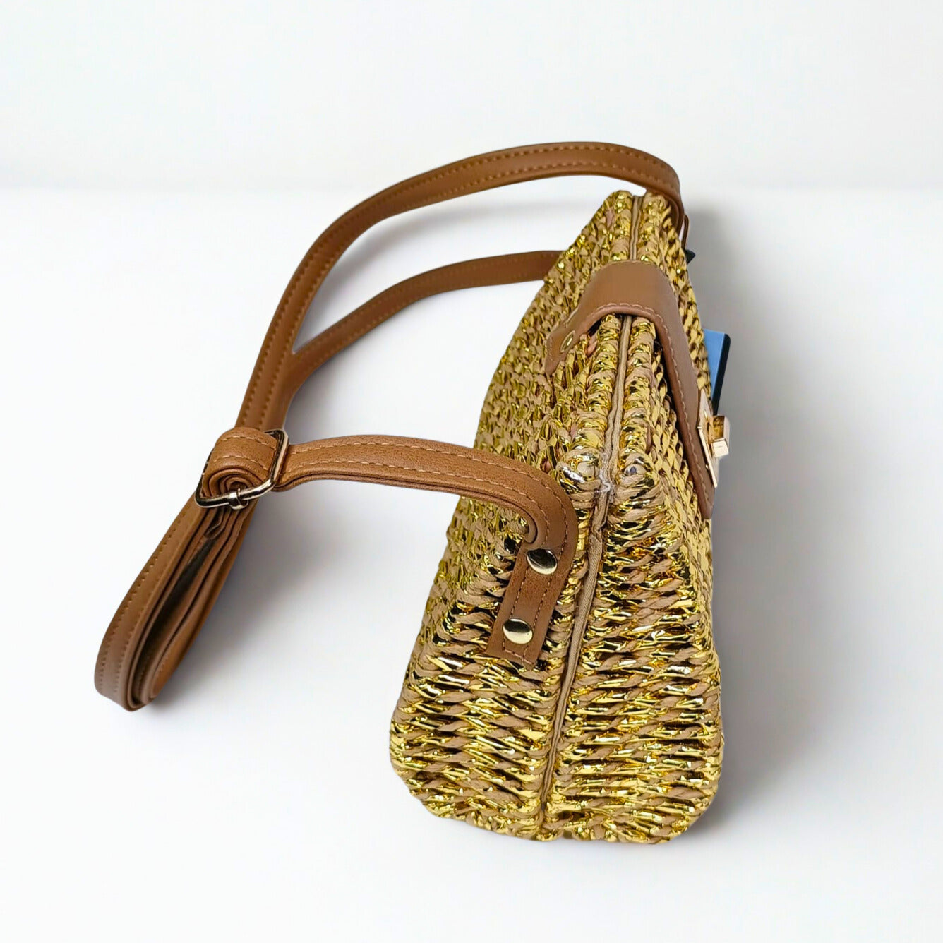 Woven handbag with brown leather straps on a white background