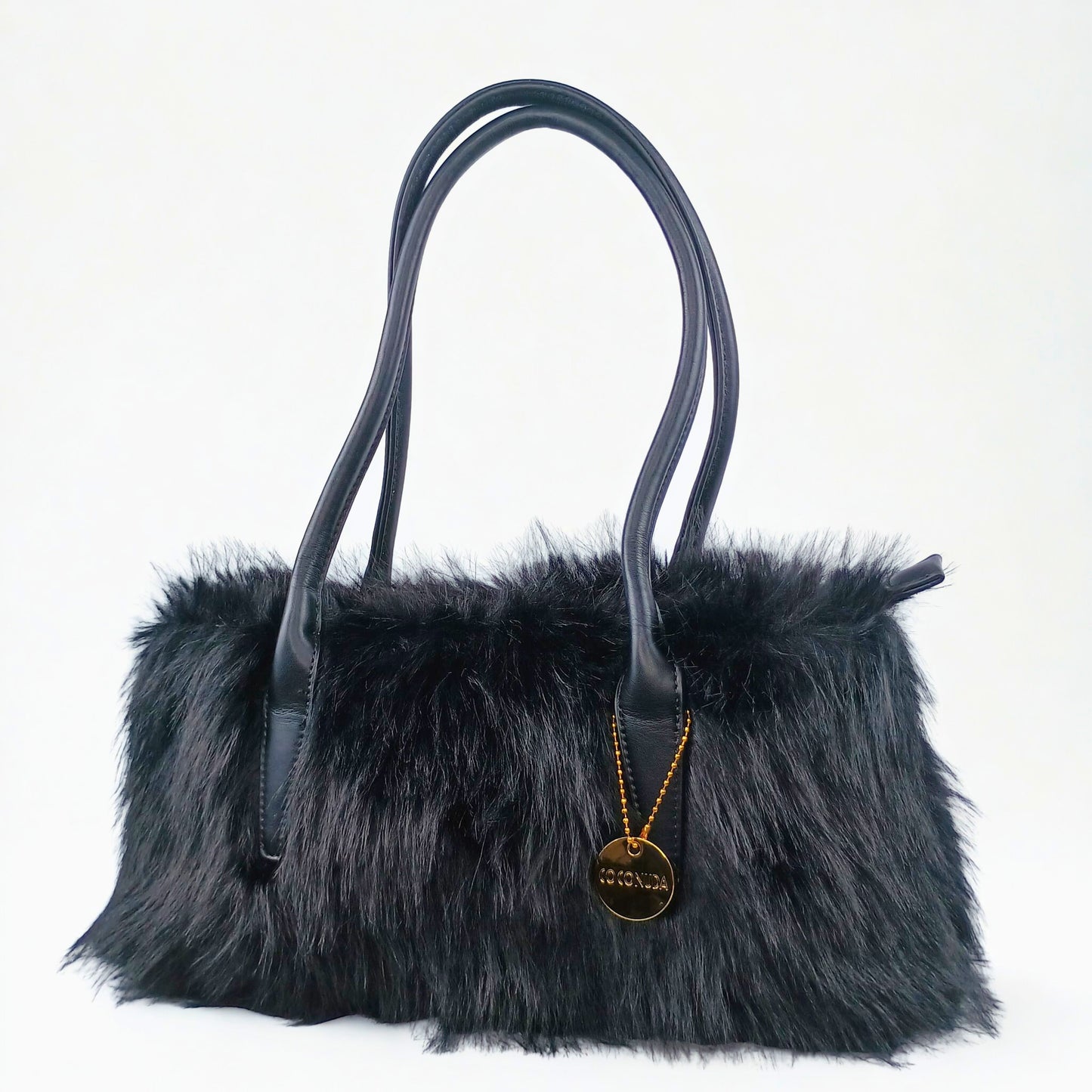 Black fur handbag with a gold pendant on a white background