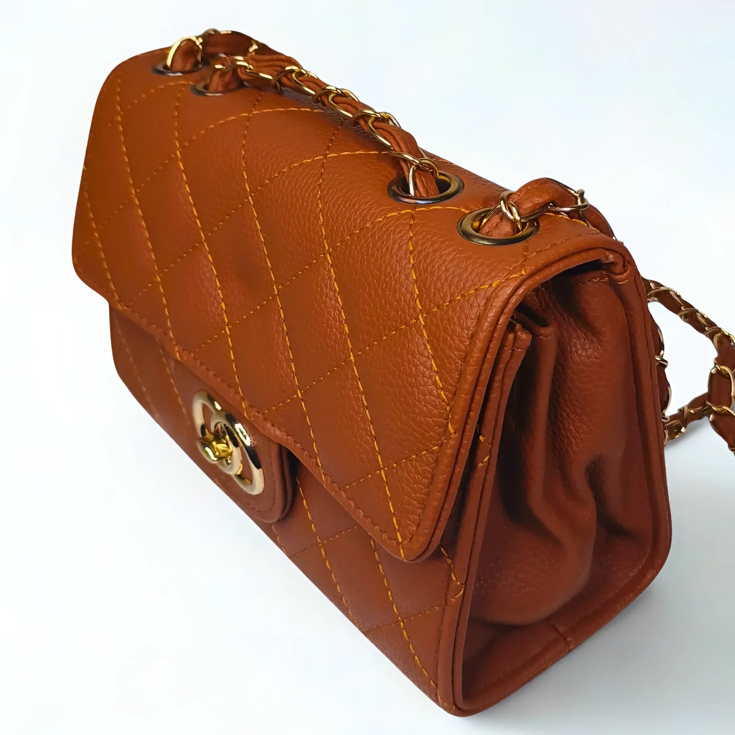 Brown leather handbag with gold chain strap on a white background