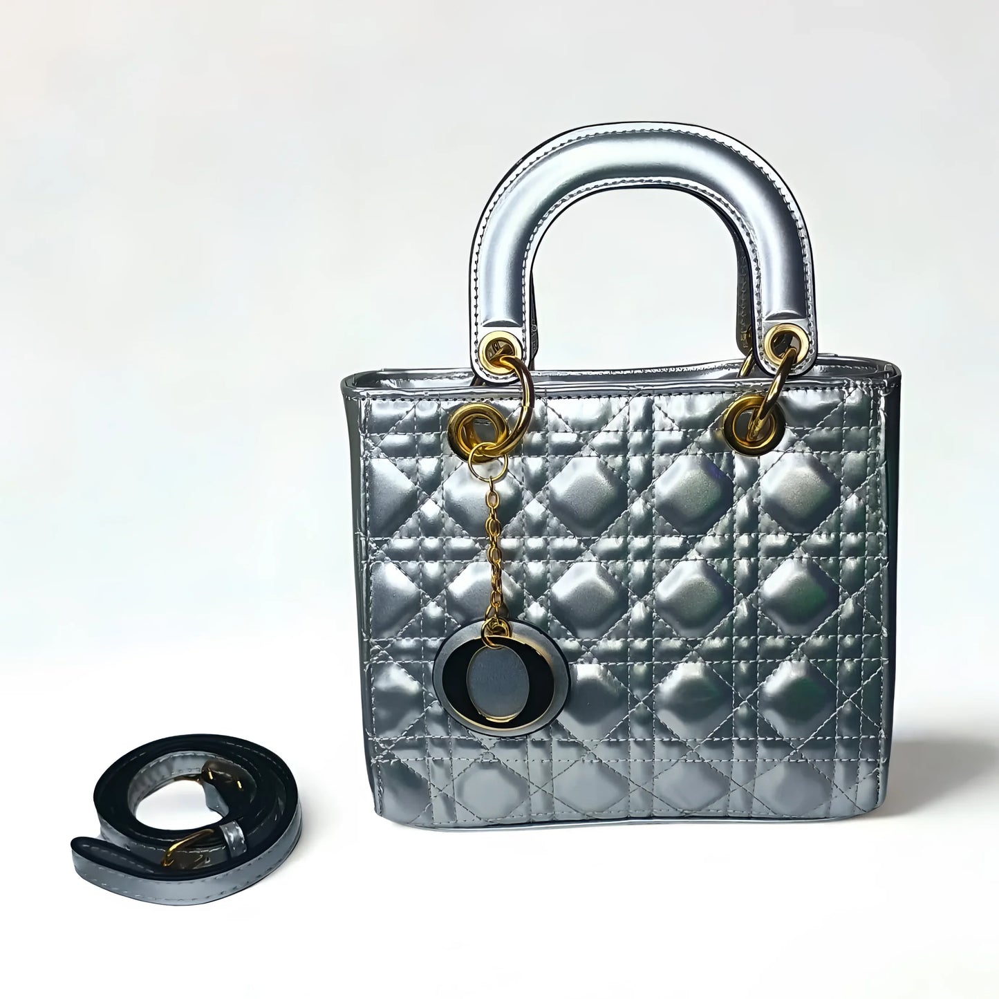 Silver quilted handbag with gold hardware and a matching keychain on a white background