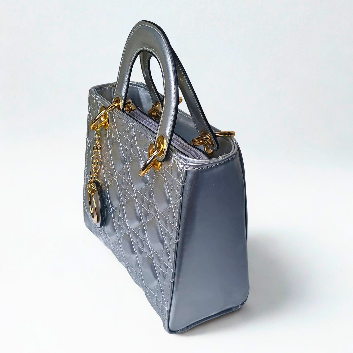 Gray handbag with gold chain detail on a white background