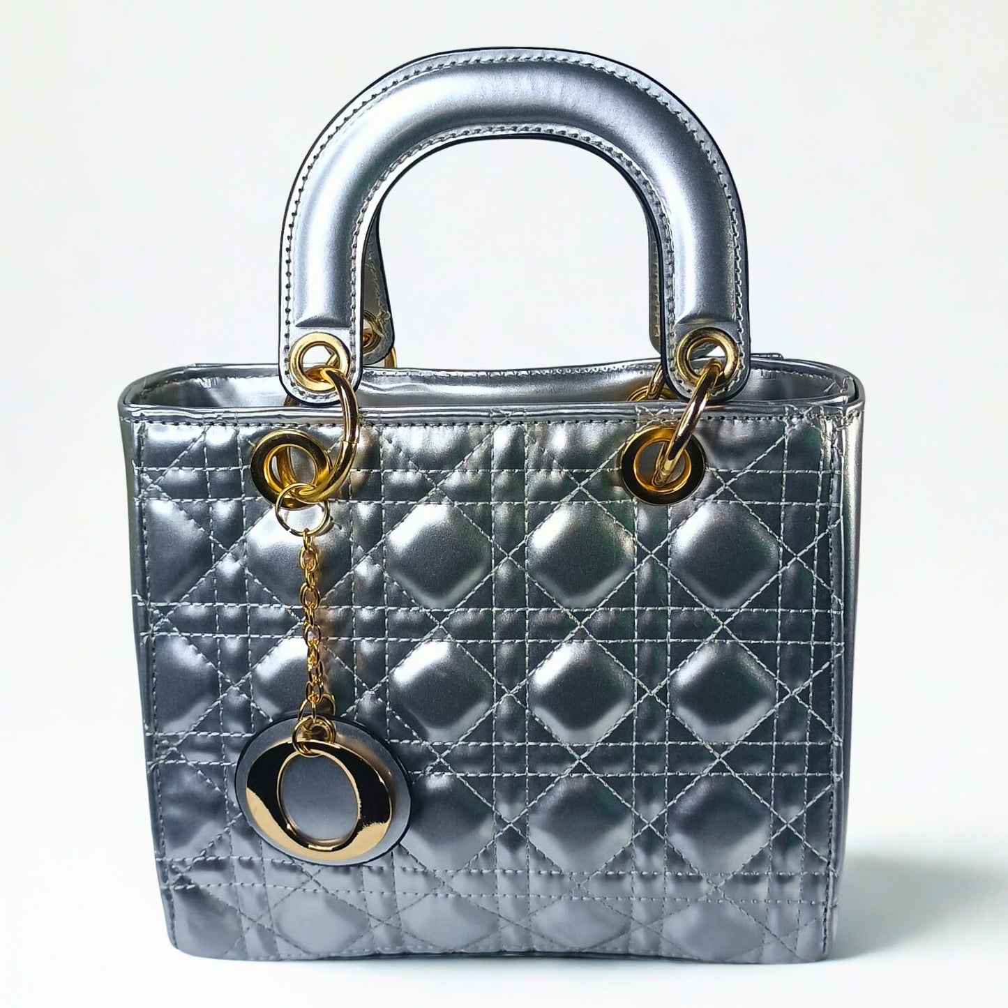 Silver quilted handbag with gold hardware on a white background