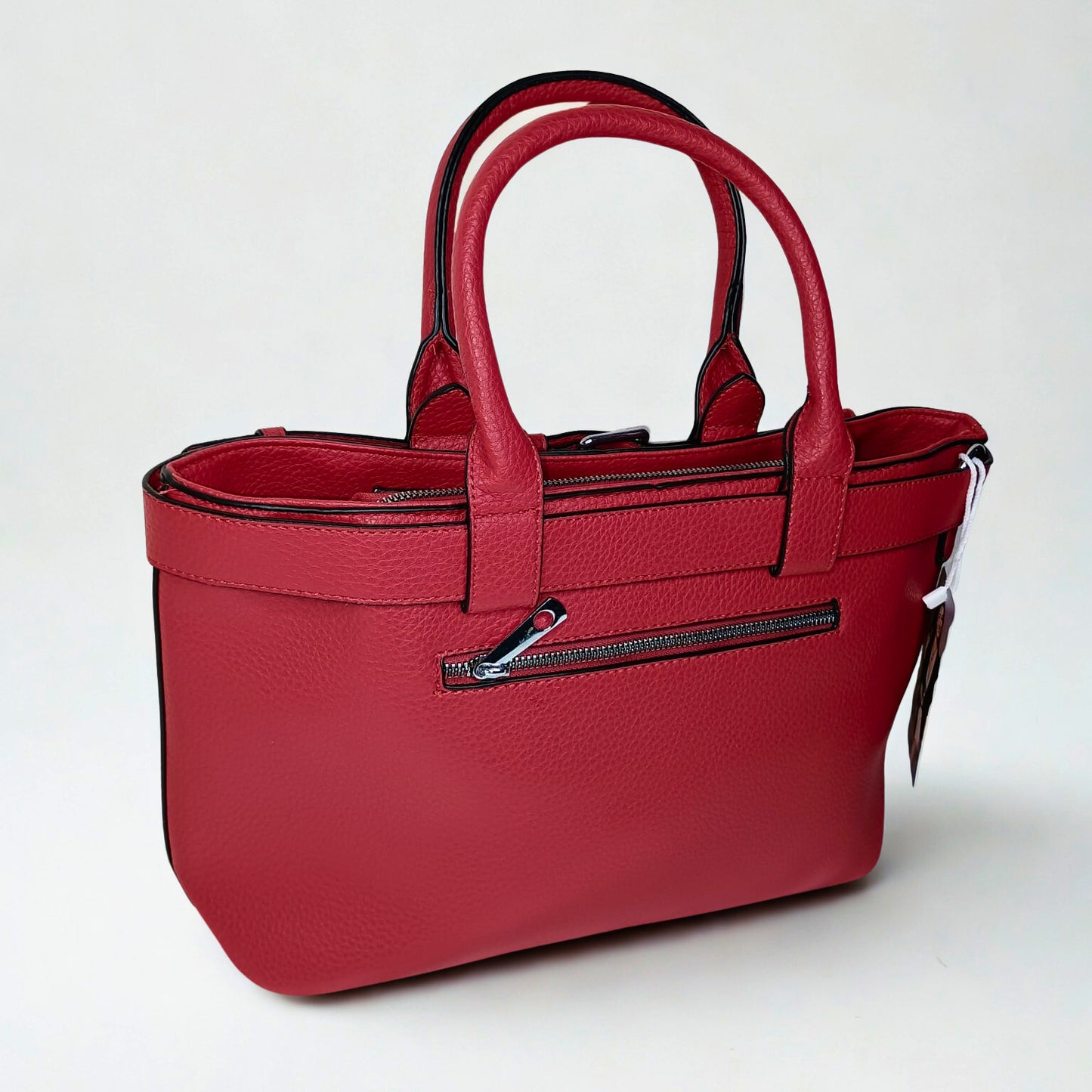 Red handbag with a visible tag on a white background