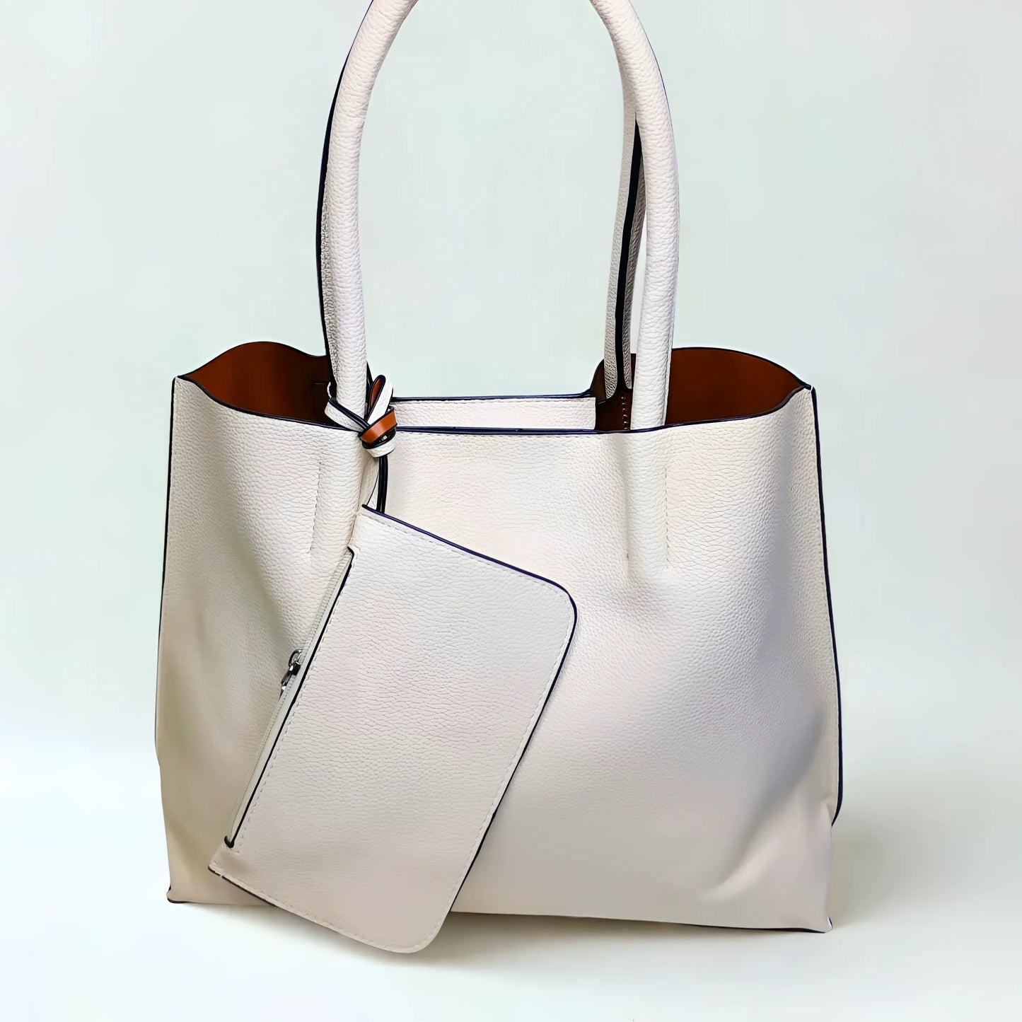 White handbag with a brown interior on a light blue background