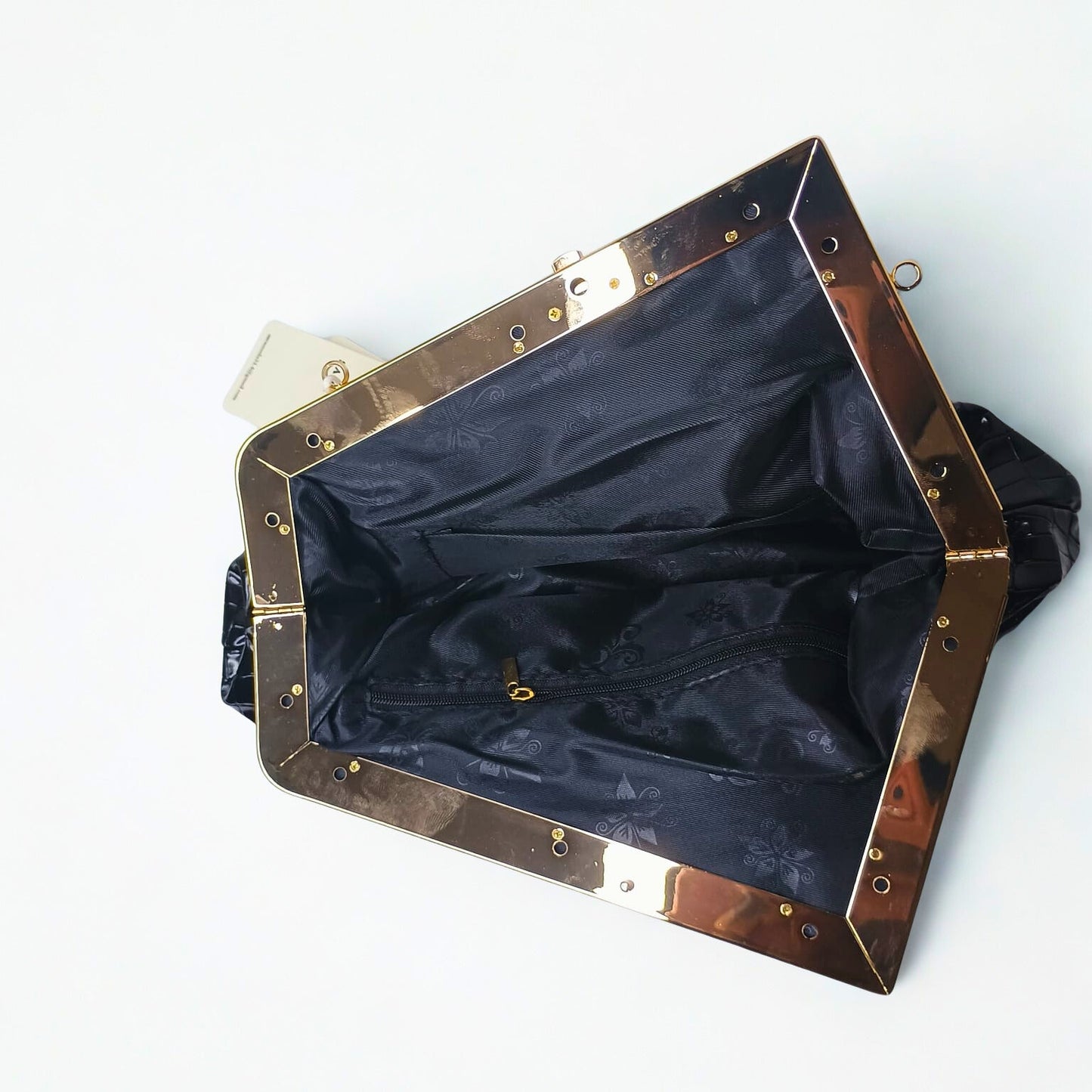 Black handbag with gold trim on a white background