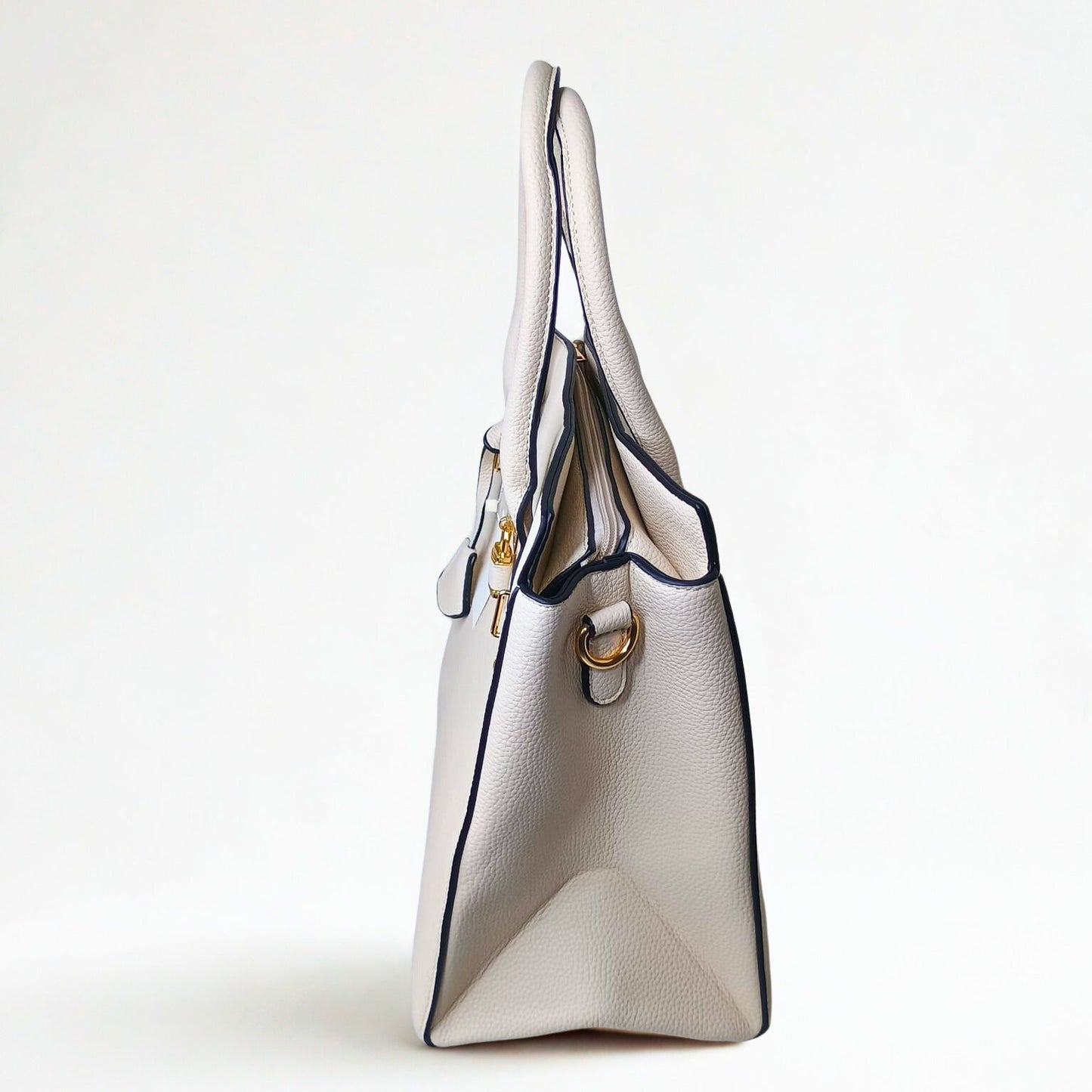 White handbag with gold accents on a light gray background