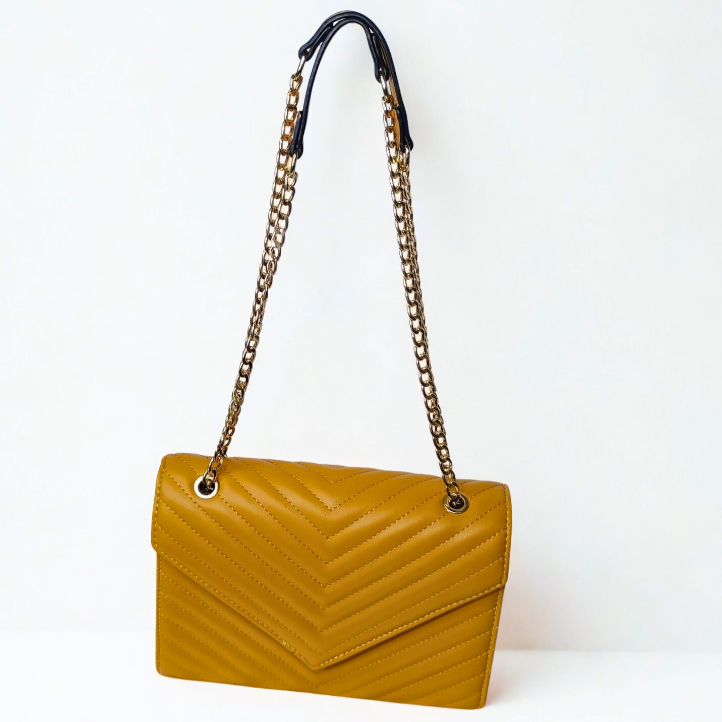 Yellow handbag with a chain strap on a white background