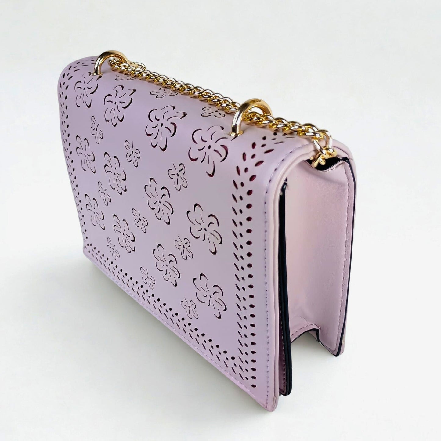 Pink handbag with floral patterns and a gold chain on a white background