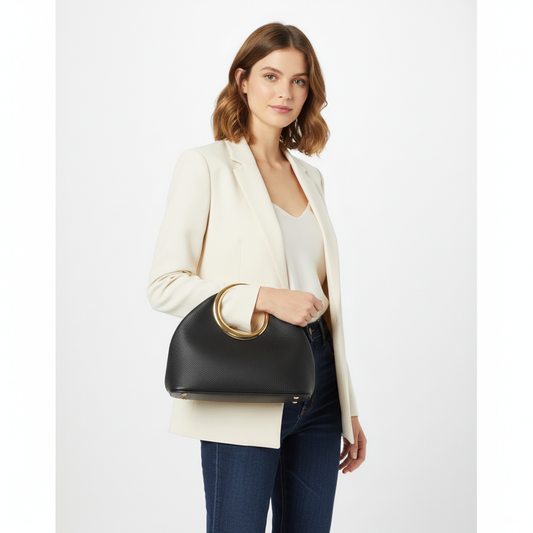 Woman holding a black handbag with gold handle on a white background