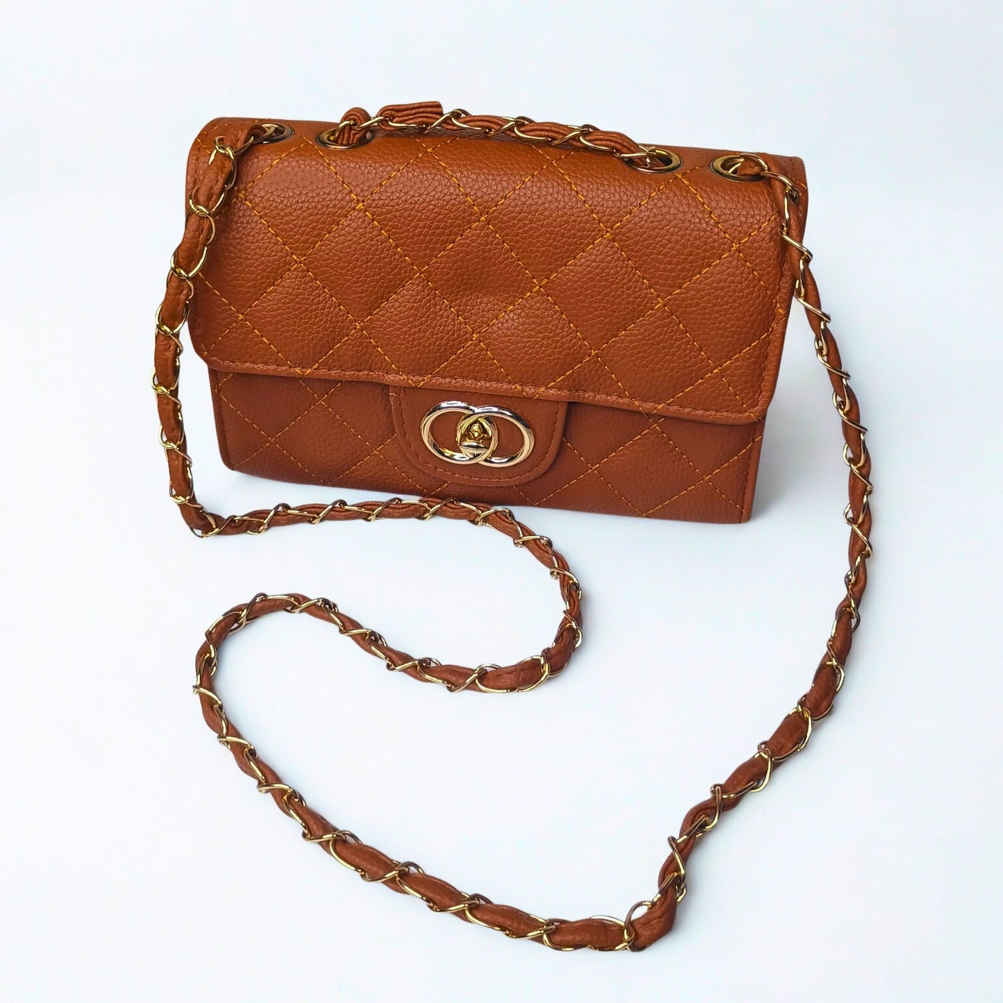 Brown quilted handbag with gold chain strap on a white background
