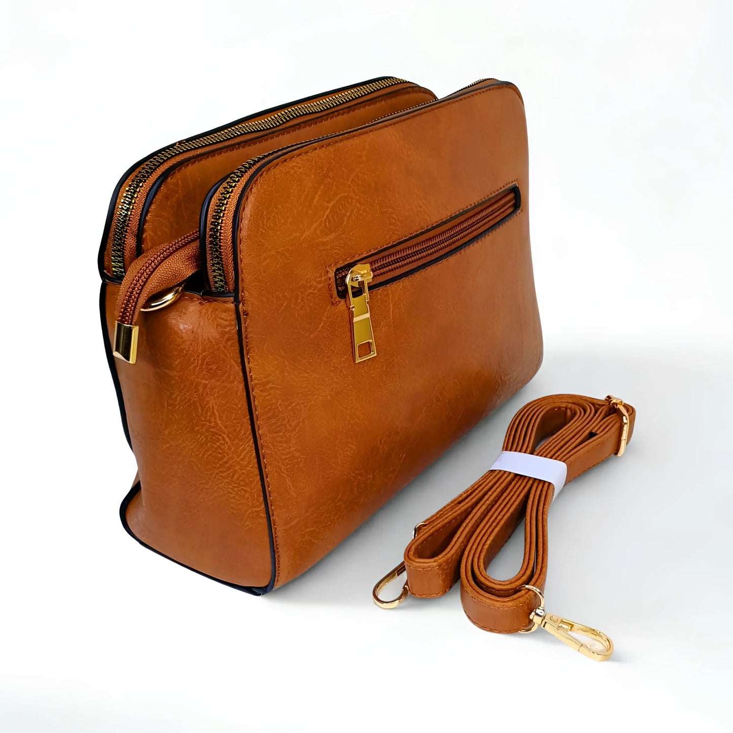 Brown leather handbag with gold zipper and strap on a white background