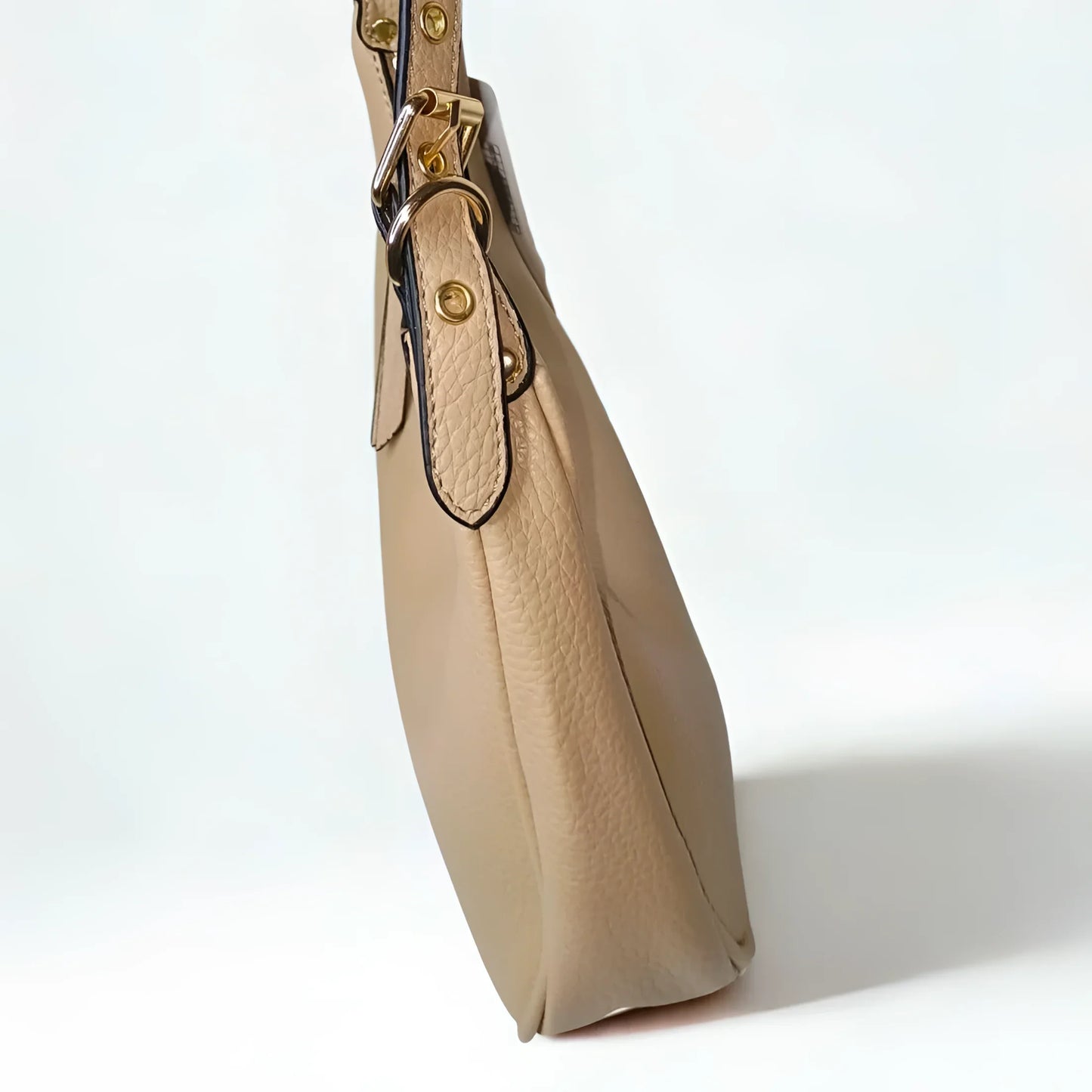 Beige handbag with gold hardware on a white background