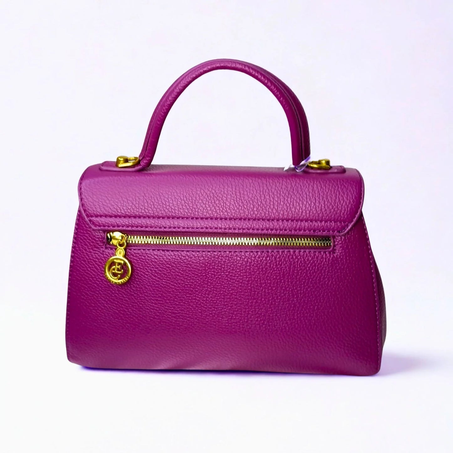 Purple handbag with gold zipper and handle on a light purple background