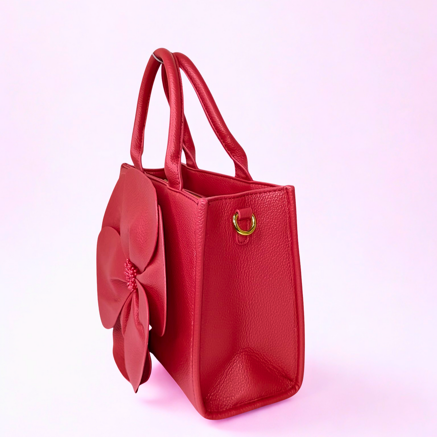 Red handbag with a large bow on a pink background
