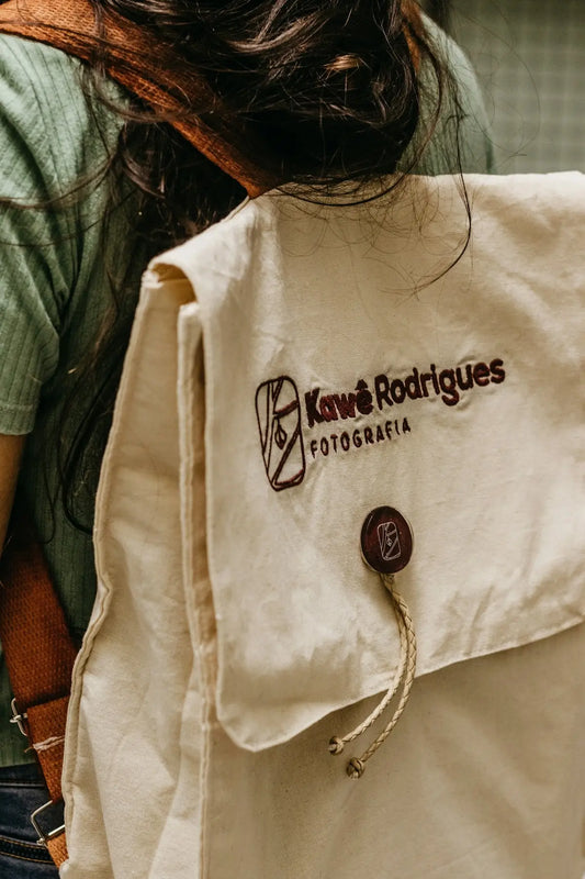 Zaino beige in canvas stile donna bags con logo ricamato marrone e chiusura a bottone.