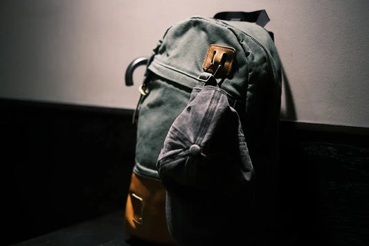 Zaino stile donna bags verde scuro con accenti pelle grigia e cappellino.
