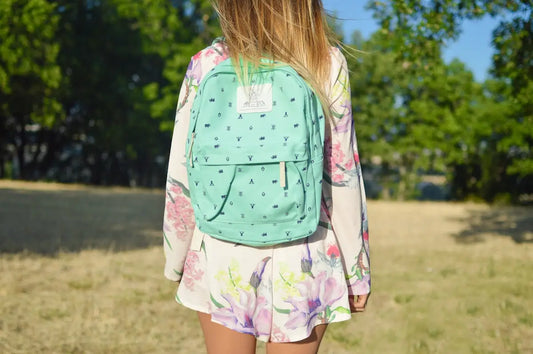 Zaino verde menta con pattern lettere nere e patch bianca per stile donna