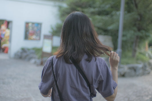 woman in black t-shirt standing on gray concrete floor during daytime