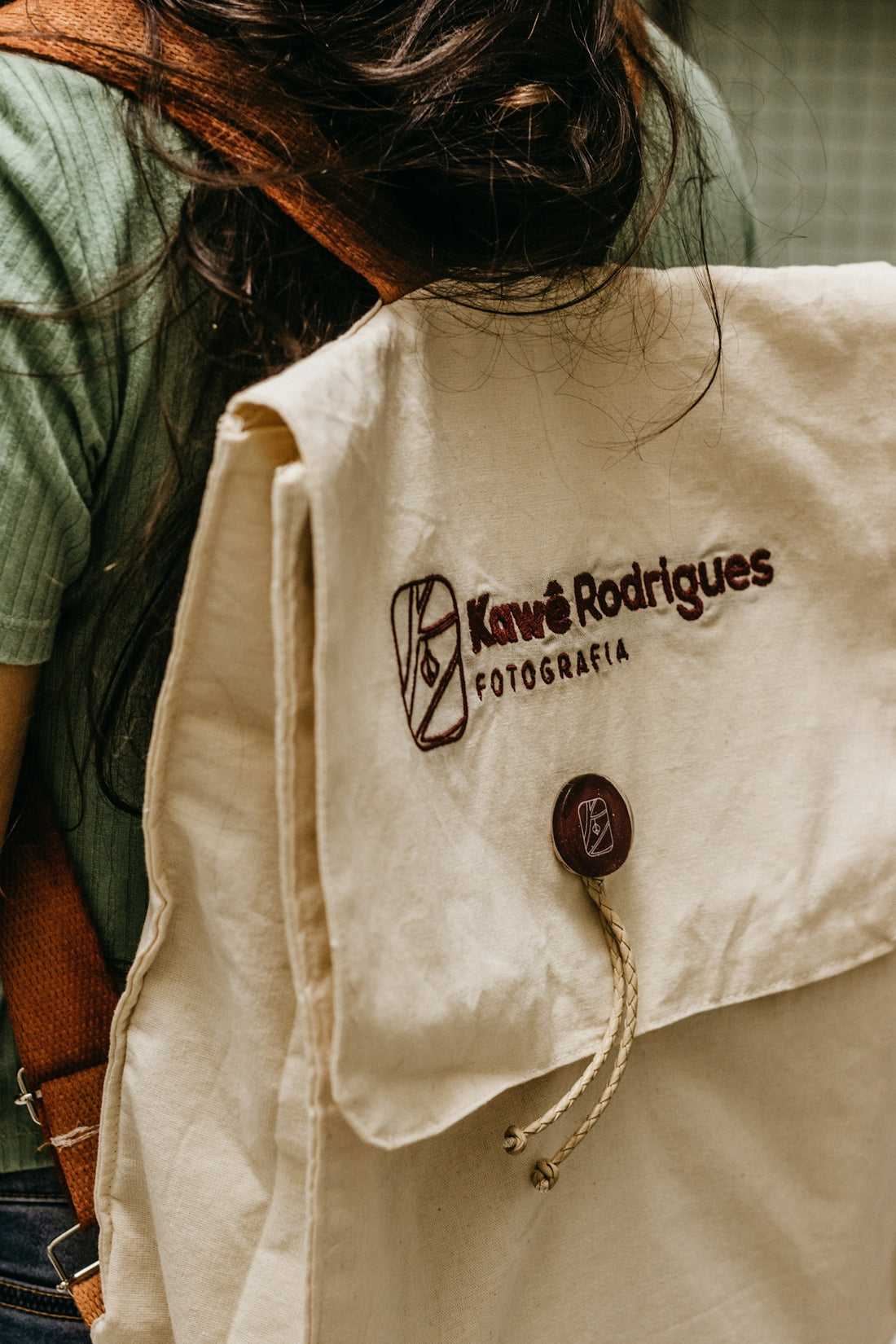 the back of a woman's backpack with a logo on it
