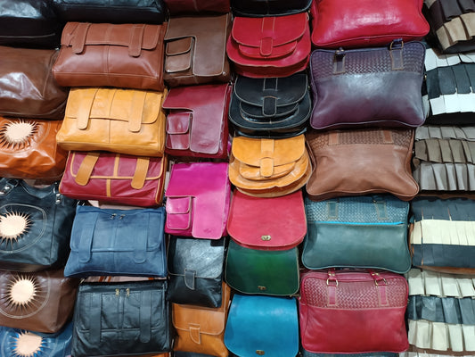 a bunch of different colored purses stacked on top of each other
