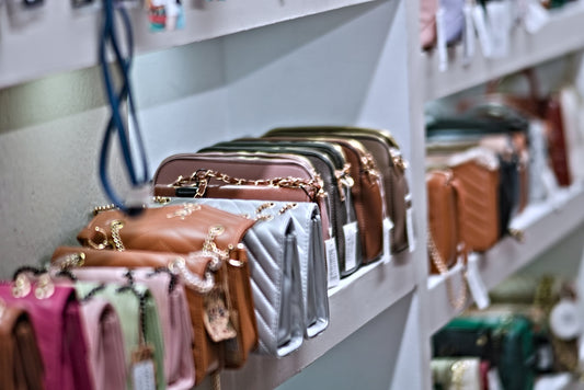 Purses are displayed on shelves in a store.