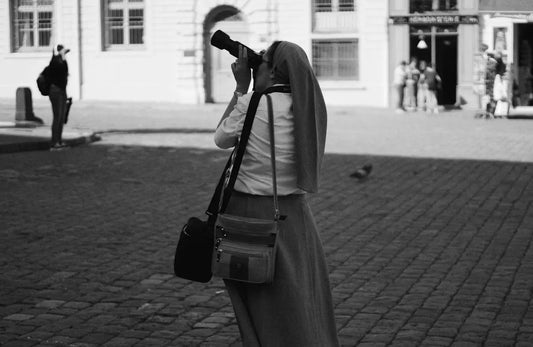 Fotografo con borsa messenger italiana elegante in bianco e nero