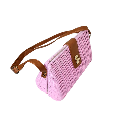 Pink woven handbag with brown strap and accents on a white background