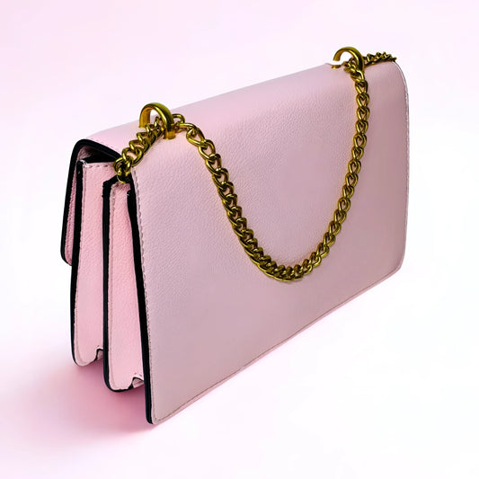 Pink handbag with a gold chain on a light pink background