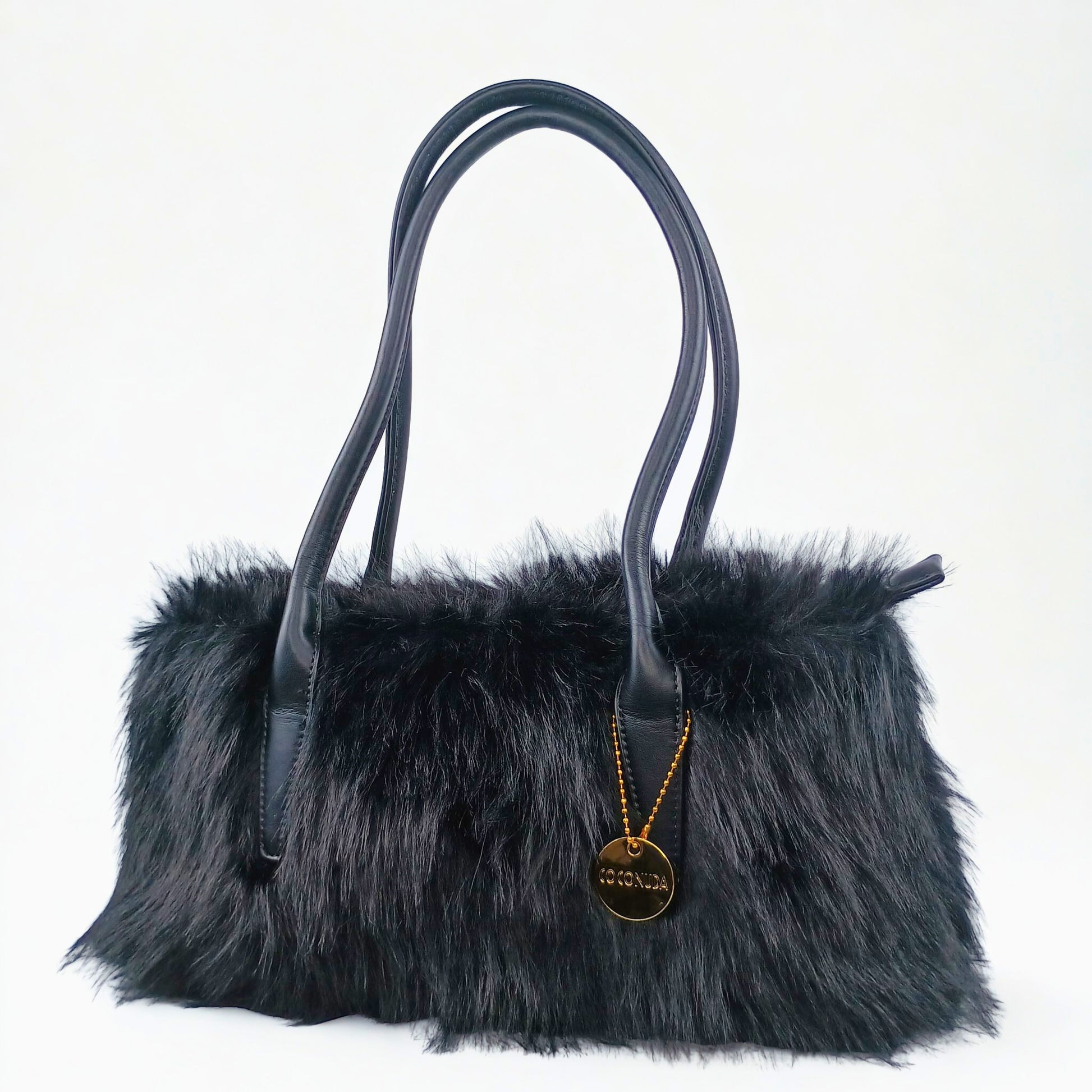 Black fur handbag with a gold pendant on a white background