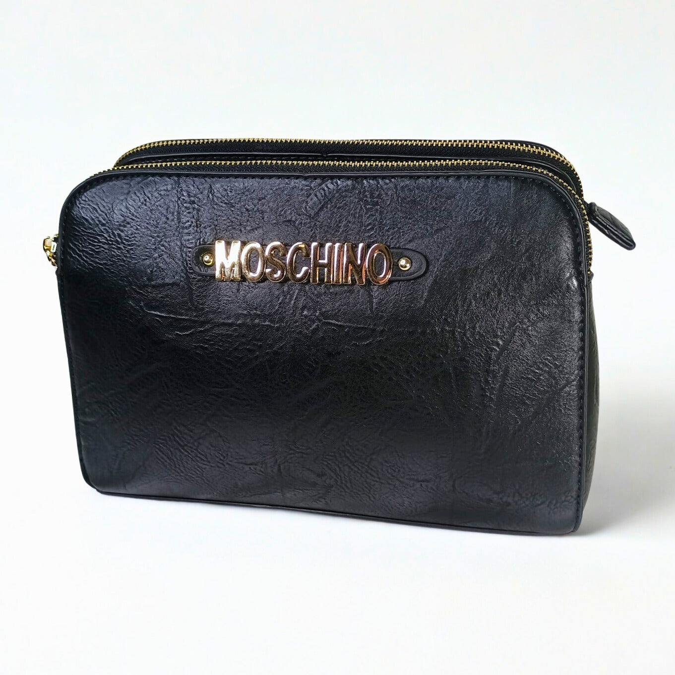 Black leather pouch with gold zipper and Moschino logo on a white background
