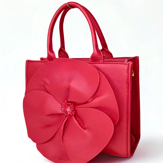 Red handbag with a large floral design on a white background