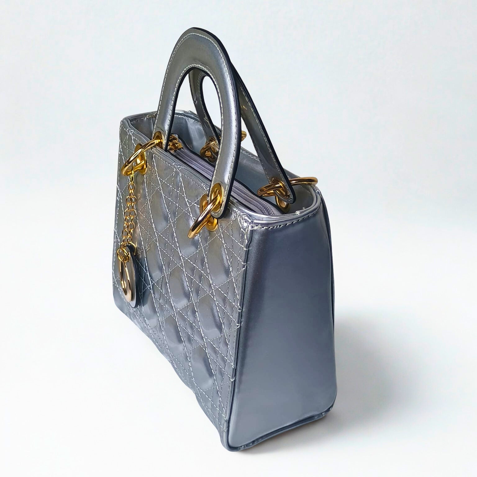 Gray handbag with gold chain detail on a white background