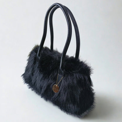 Black fur handbag with a gold tag on a light gray background