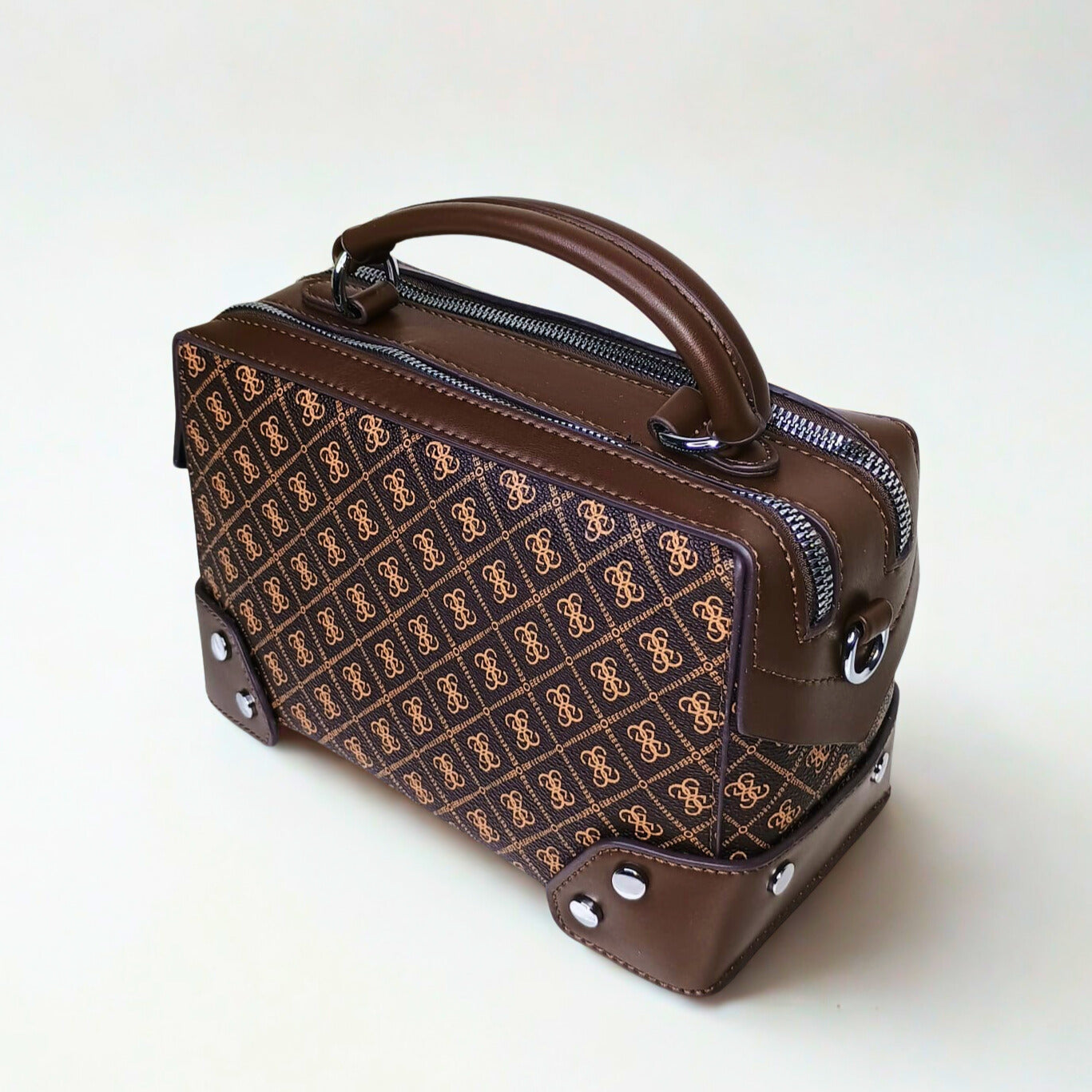 Brown handbag with patterned front section on a white background
