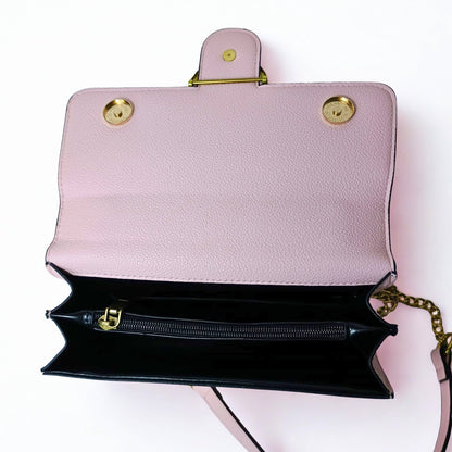 Pink handbag with gold accents on a white background