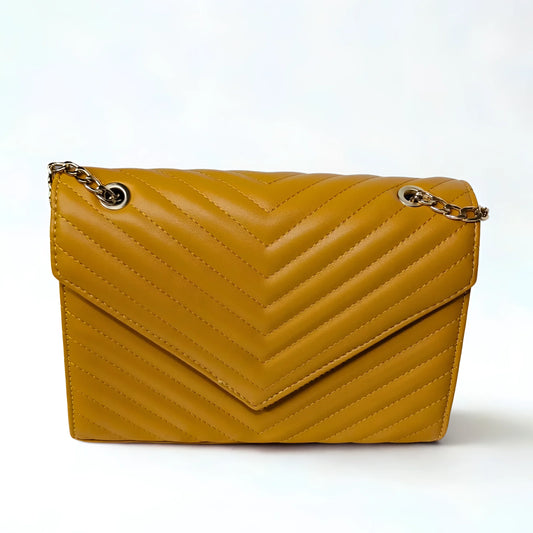 Yellow quilted handbag with gold chain on a white background