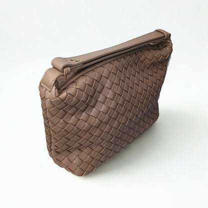 Brown woven handbag on a white background