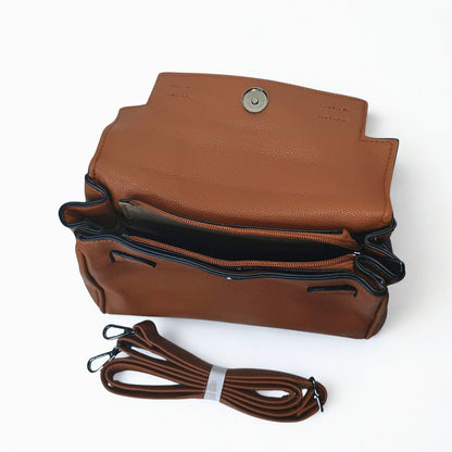 Brown leather handbag with a strap on a white background