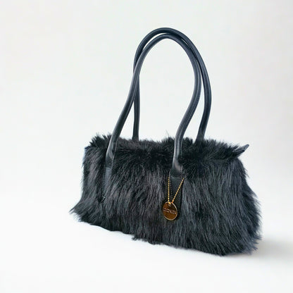 Black fur handbag with leather handles on a white background