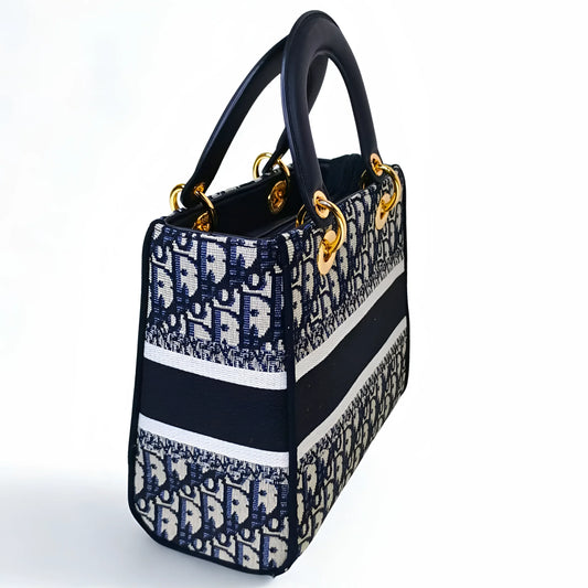 Designer handbag with black, white, and blue pattern on a white background