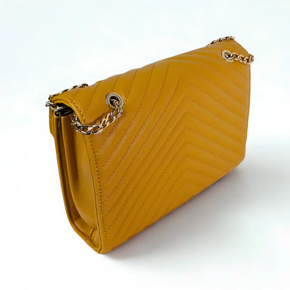Yellow handbag with a gold chain strap on a white background