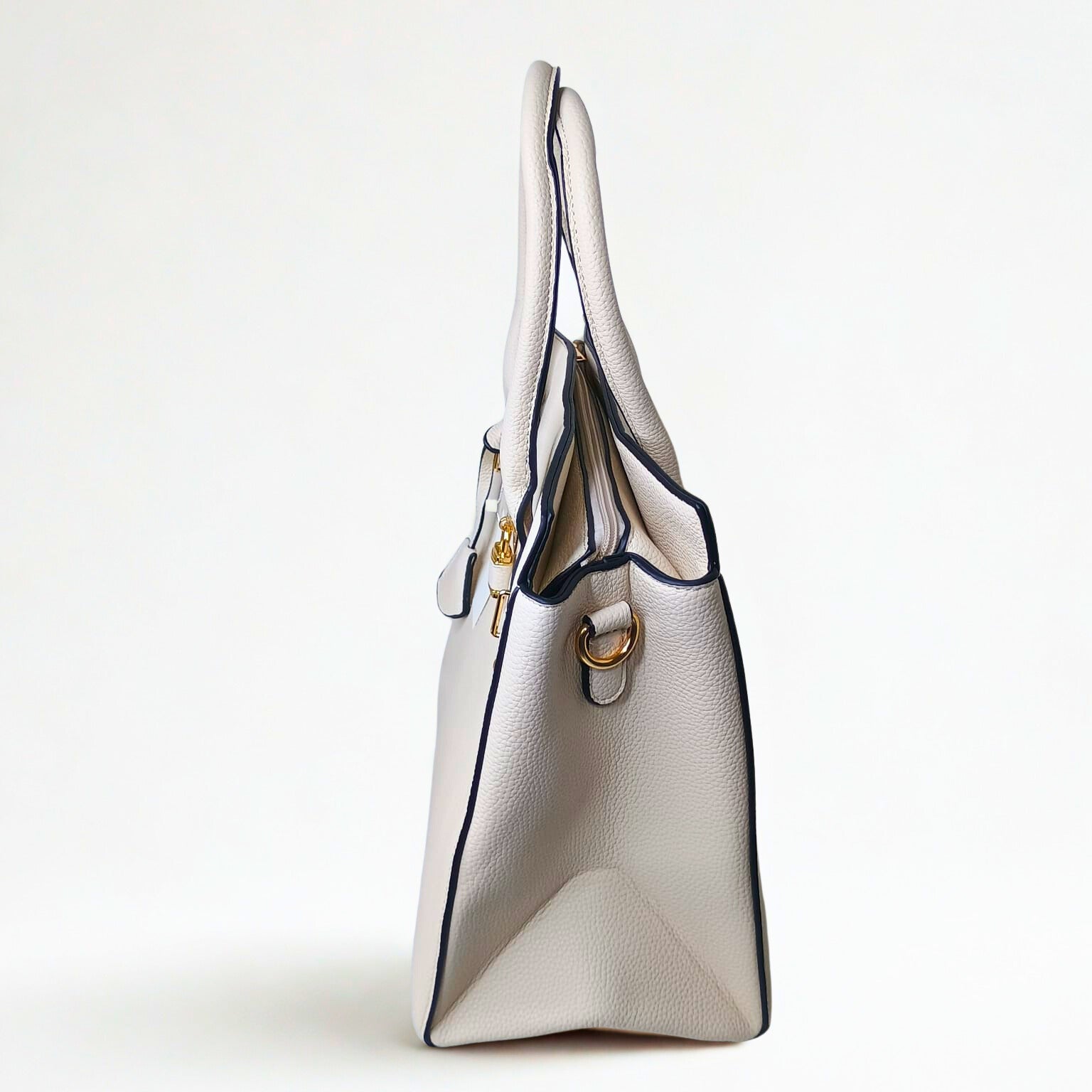 White handbag with gold accents on a light gray background