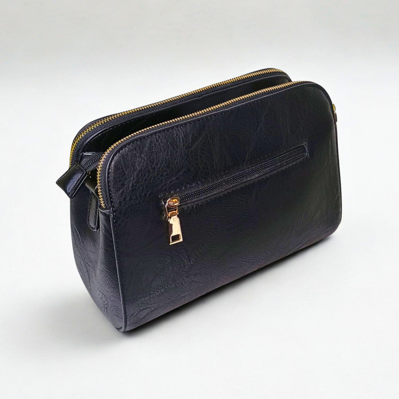 Black leather handbag with gold zipper on a white background