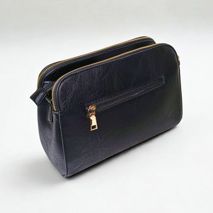 Black leather handbag with gold zipper on a white background