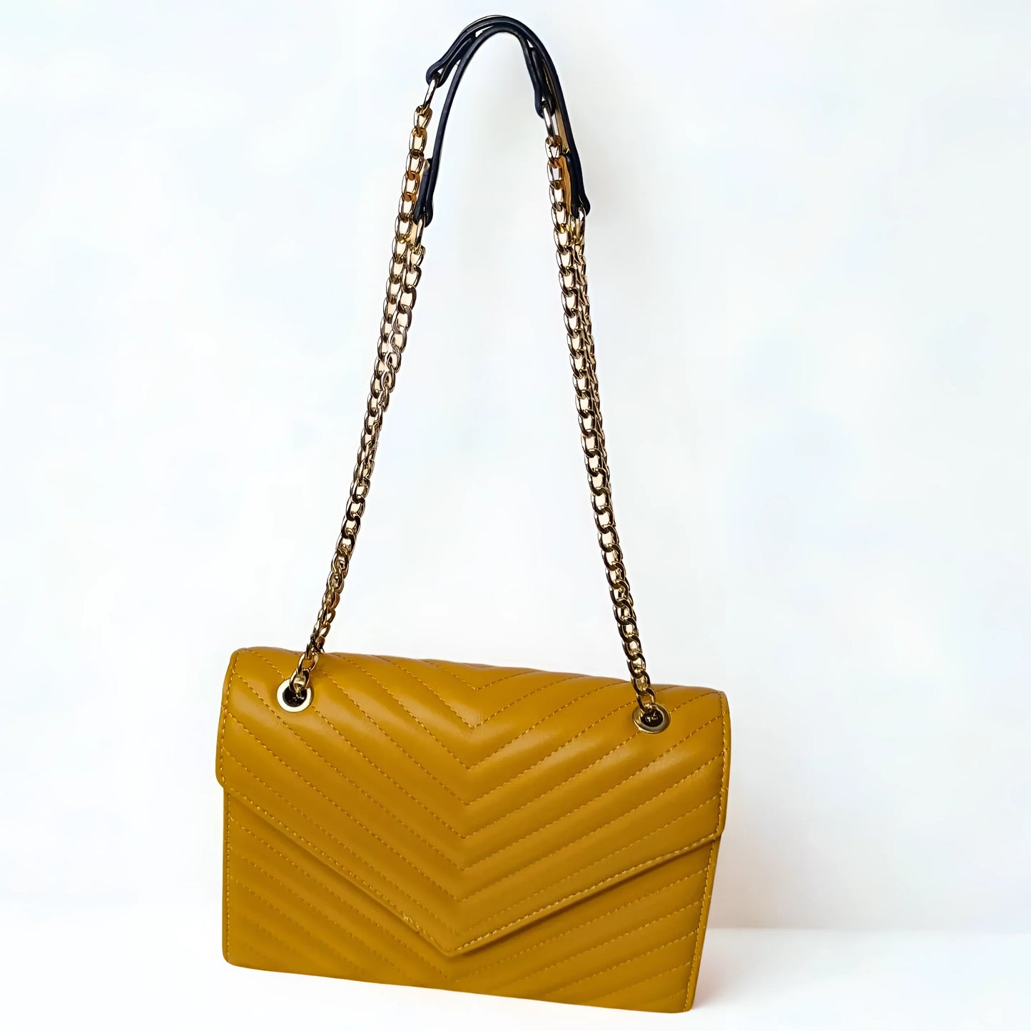 Yellow handbag with a chain strap on a white background