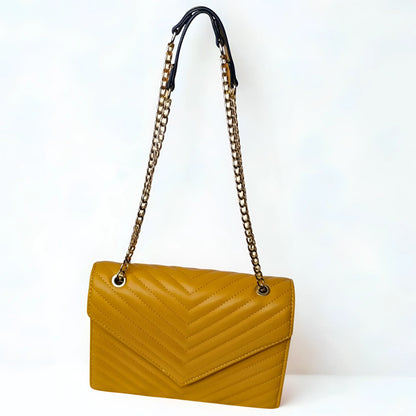 Yellow handbag with a chain strap on a white background