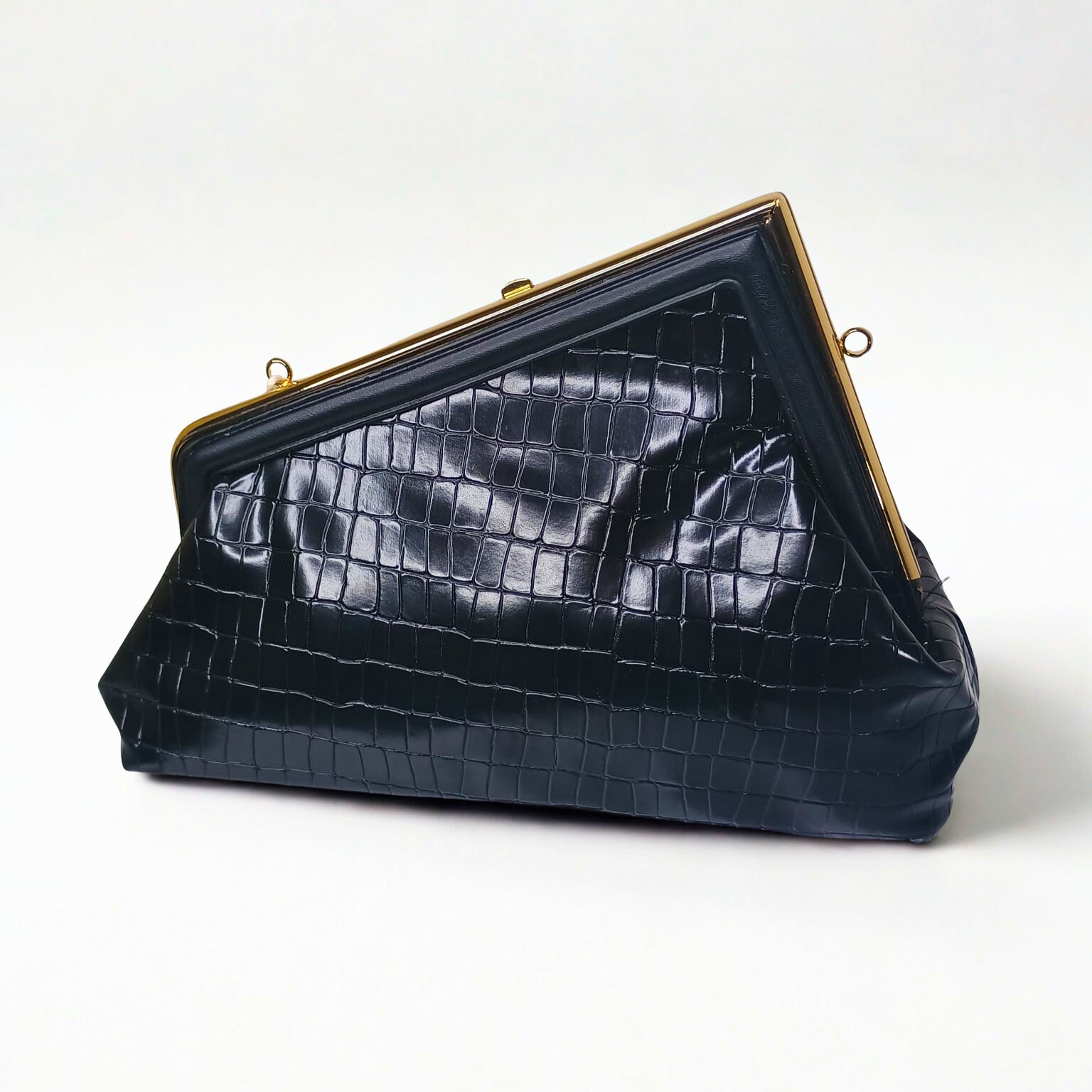 Black crocodile-patterned handbag with gold frame on a white background