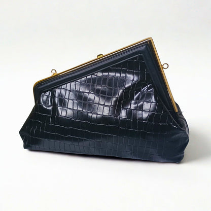 Black crocodile-patterned handbag with gold frame on a white background
