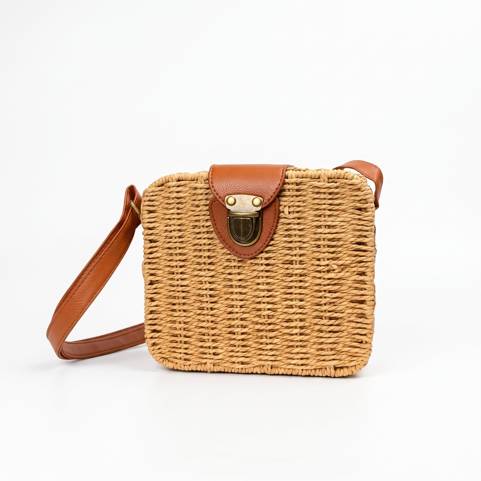 Woven handbag with brown leather strap and clasp on a white background