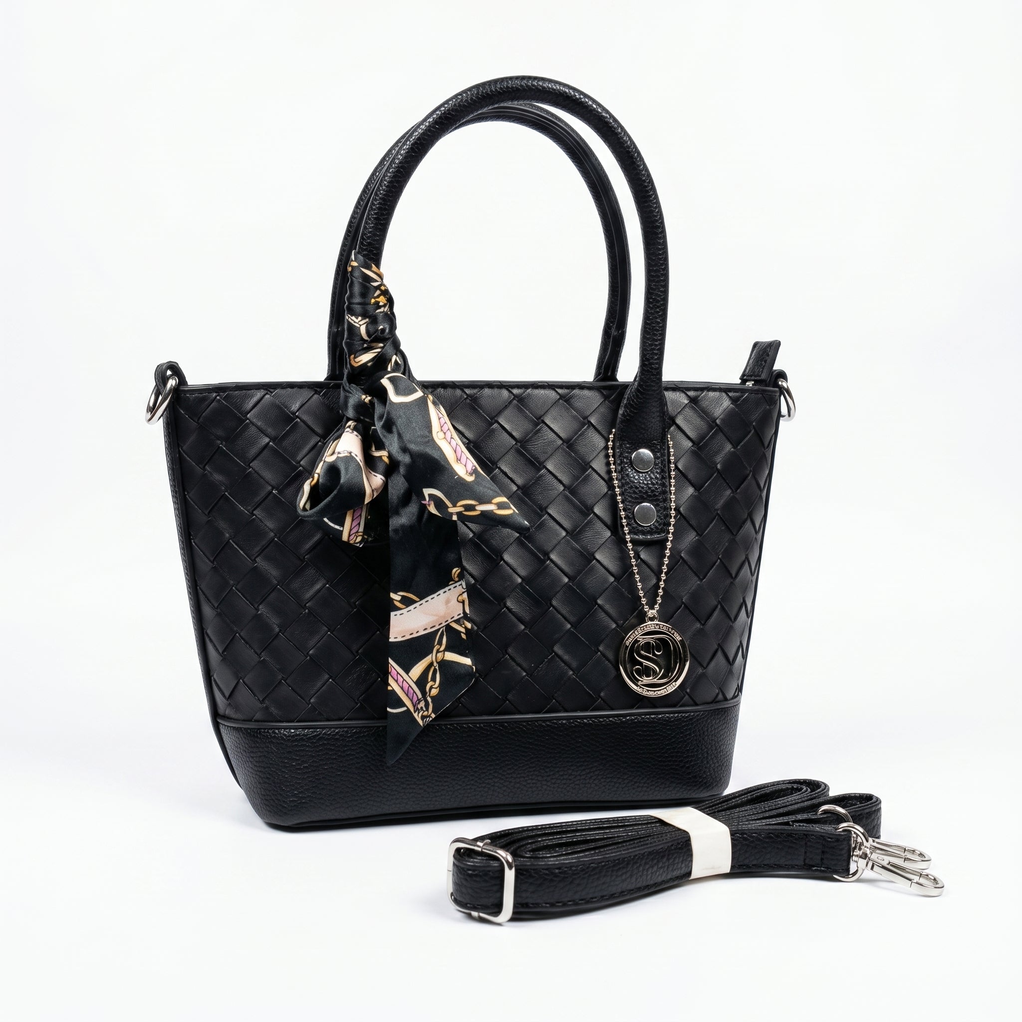 Black woven handbag with a matching scarf and detachable strap on a white background